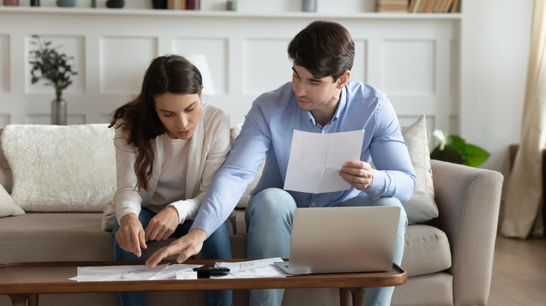 Couple paying bills on couch 