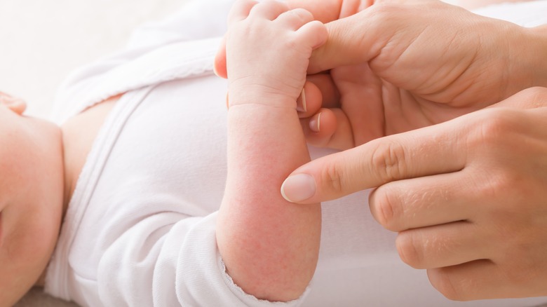 mother touching baby's skin