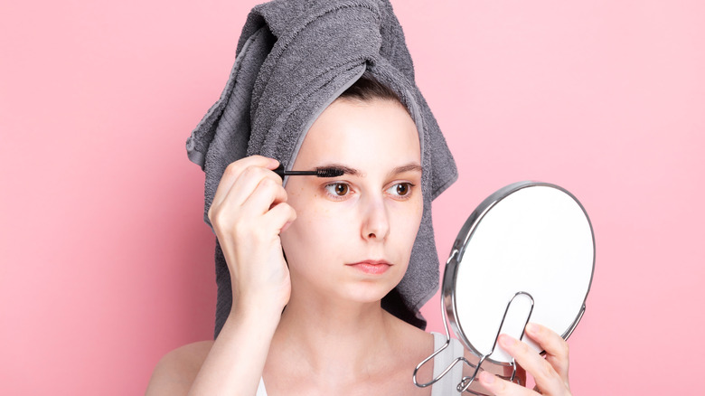 Woman applying makeup to her eyebrows