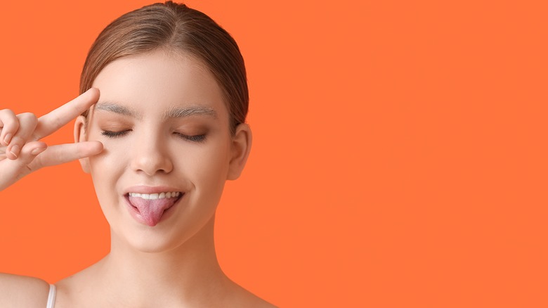 Woman with bleached brows sticking out her tongue