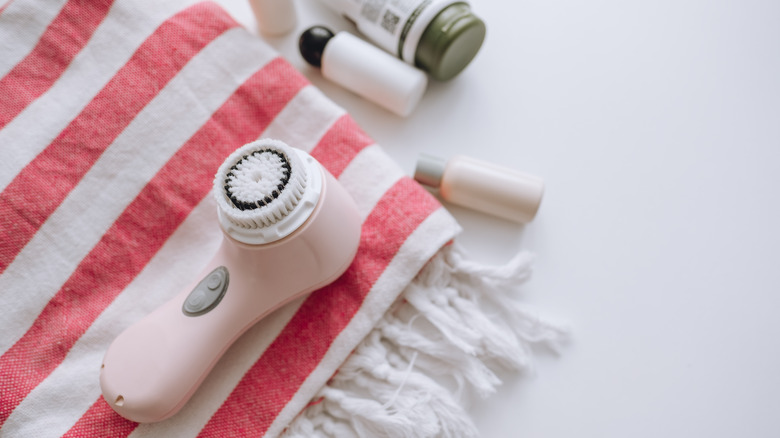 Facial cleansing brush on towel