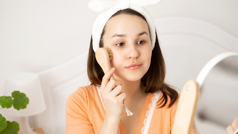 Woman using manual facial cleansing brush