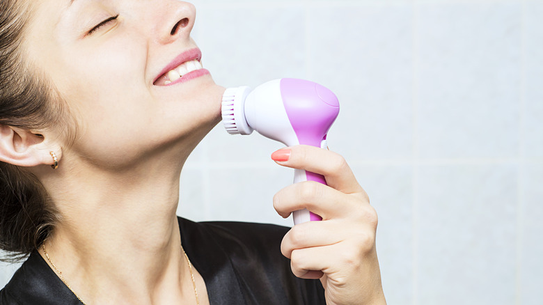 Woman using face brush