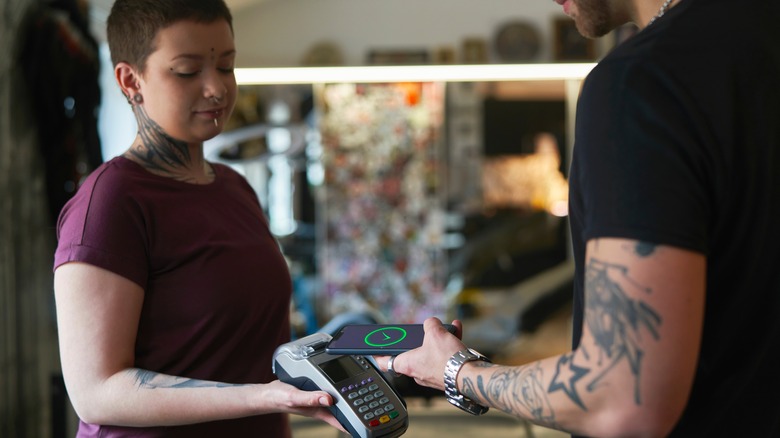 man paying for a piercing