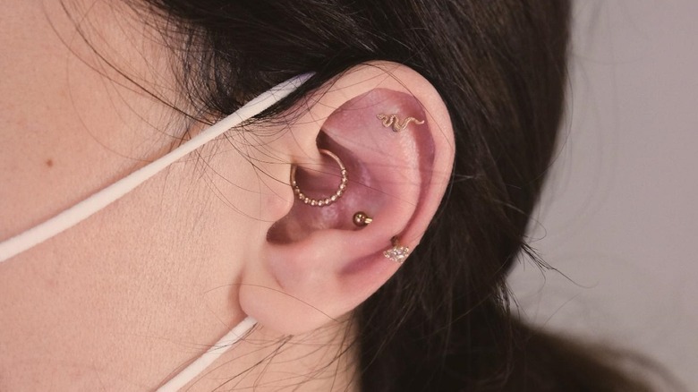 woman's ear with multiple piercings