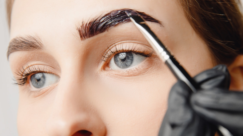 Eyebrow dye being applied to a woman's eyebrow