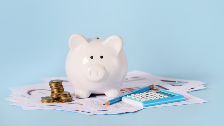 A piggy bank pictured with money and a calculator