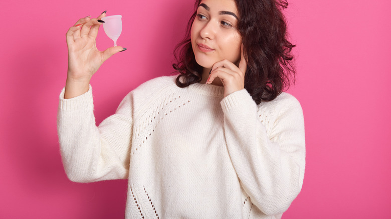 woman examining menstrual cup