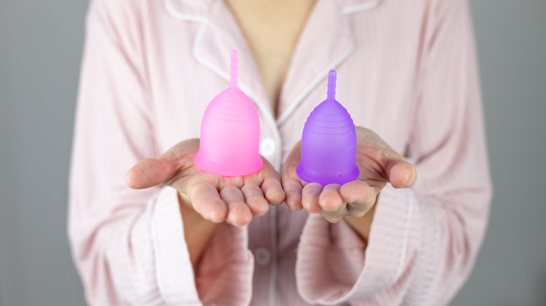 woman holding menstrual cups