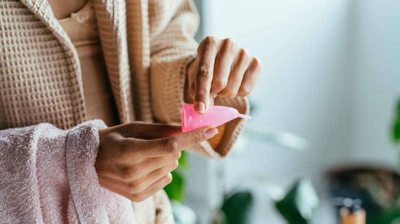 woman folding menstrual cup