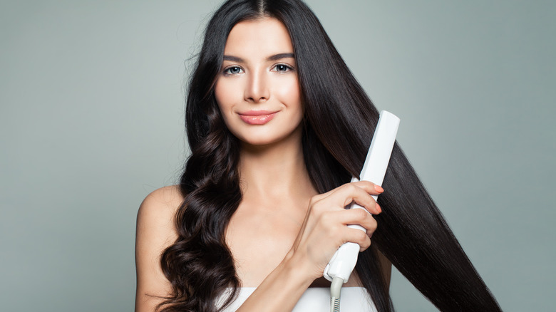 Woman straightening her long hair