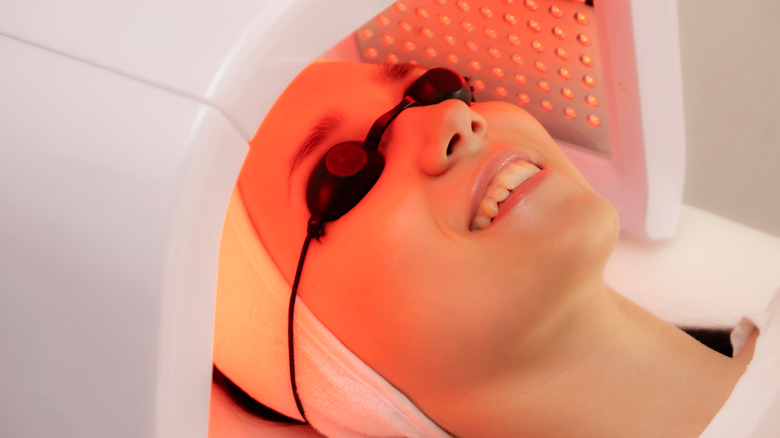 A smiling woman getting LED light therapy