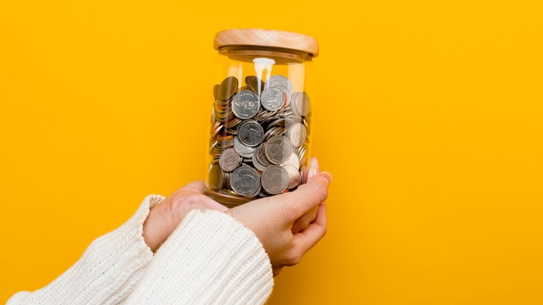 hands holding savings jar