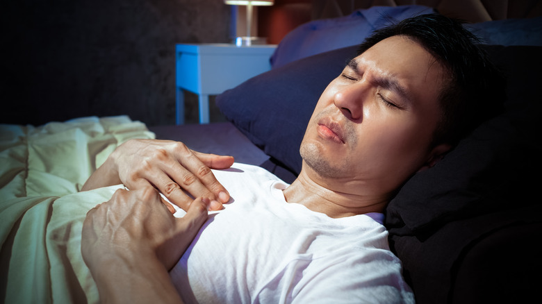 Man lying in bed in pain