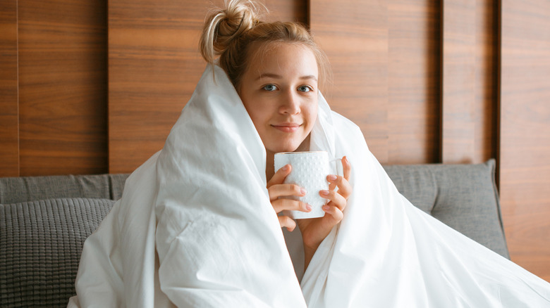 woman wrapped in a blanket and enjoying a hot beverage
