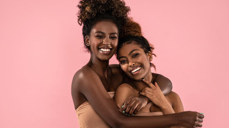 two smiling women hugging each other