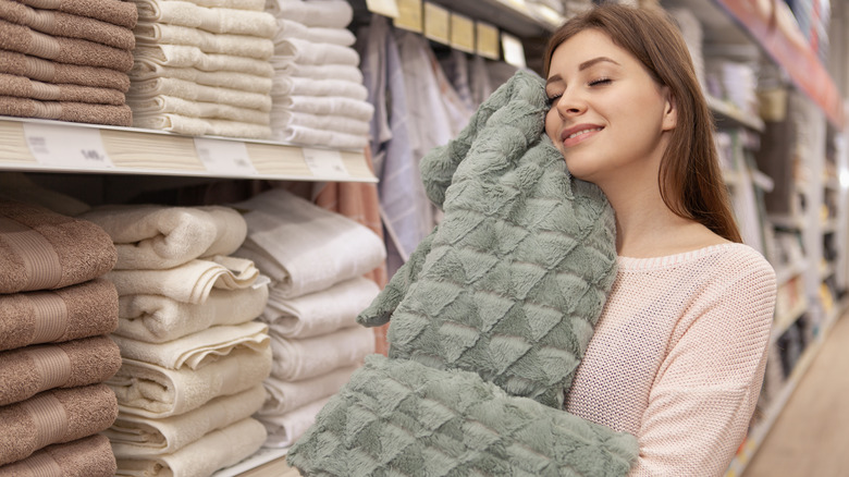 woman feeling the texture of a blanket in a store