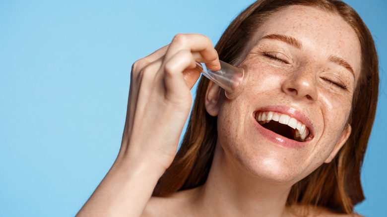 Woman placing a facial cup on her cheek