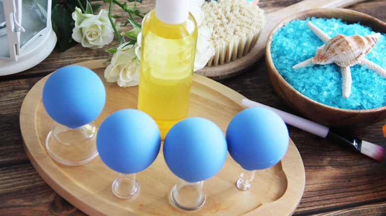 A facial cupping kit placed on a tray with a container filled with oil