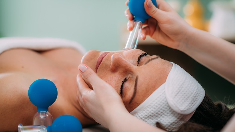 Woman getting facial cupping at a salon