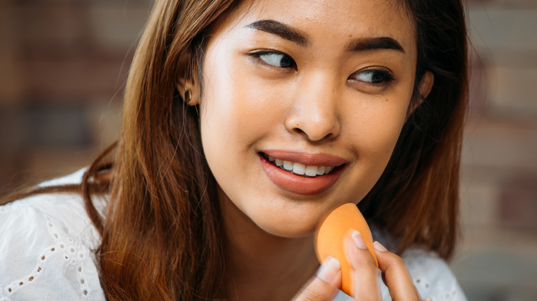 Woman putting face makeup on