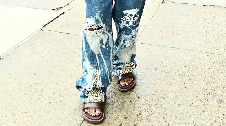 Person in distressed jeans and sandals