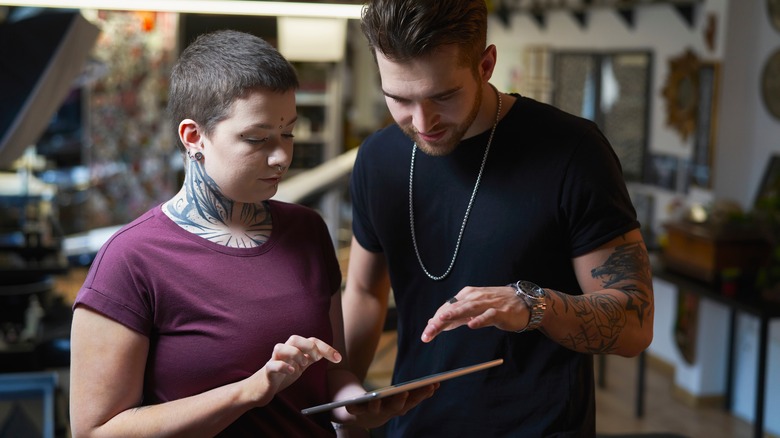 Man consults with tattoo artist 
