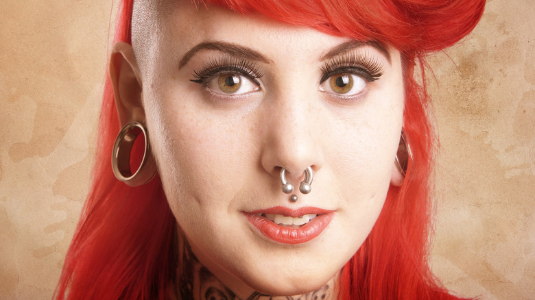 Redheaded woman with face piercings 