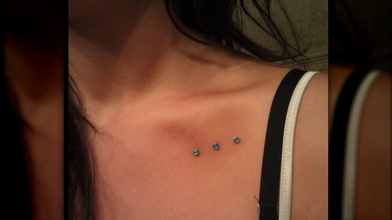 Three collarbone dermal piercings 