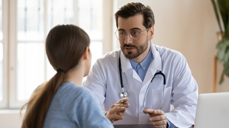 Male doctor speaking to a female patient