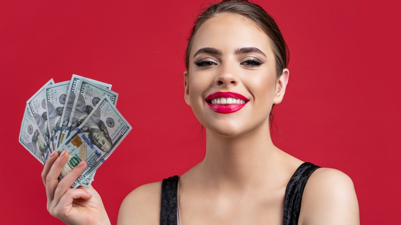 A smiling woman holding money