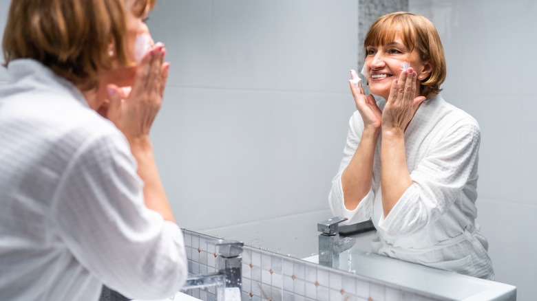 Older woman cleansing face