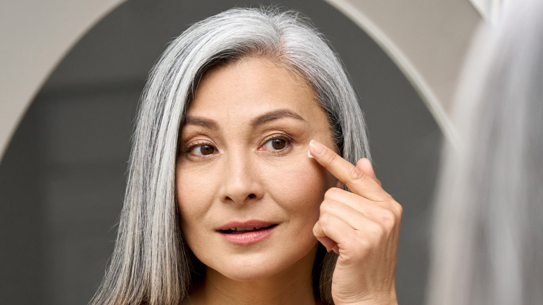 Older woman applying eye cream