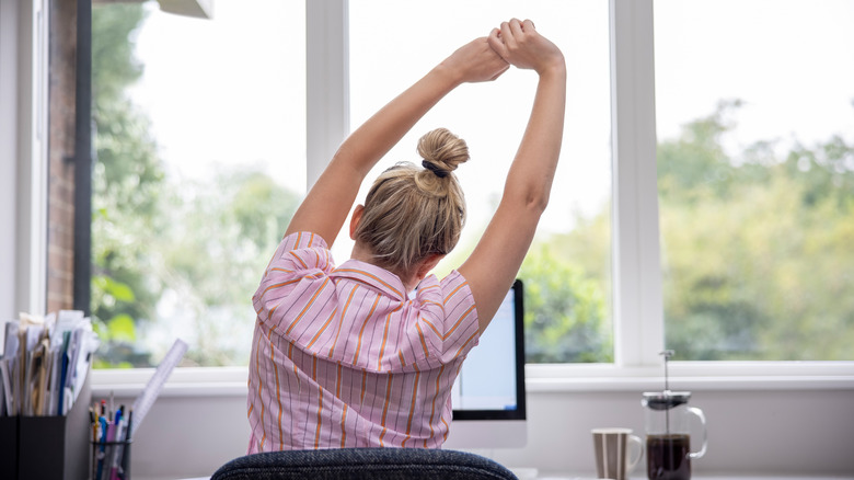 Woman stretching at her desk