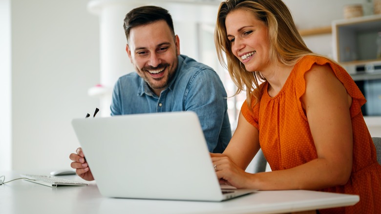 couple writing their wedding vows on a laptop