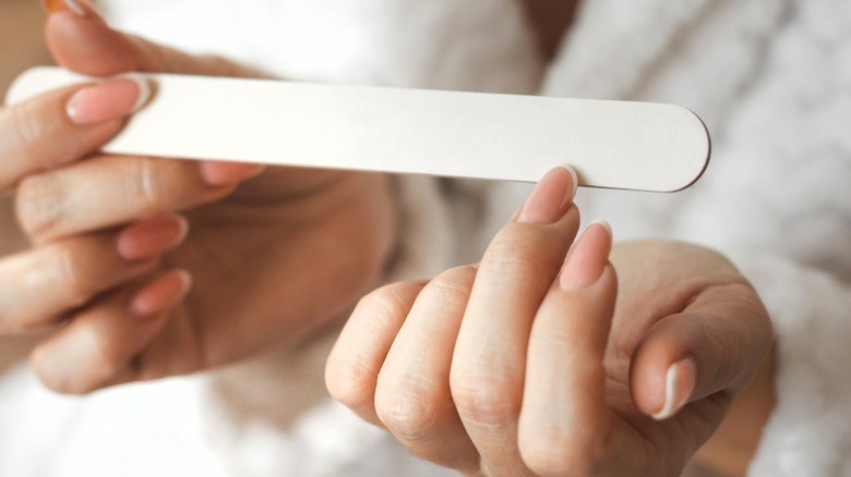 woman filing her acrylic nails