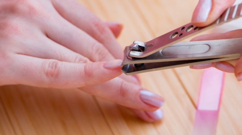 Close-up of clipping painted nails