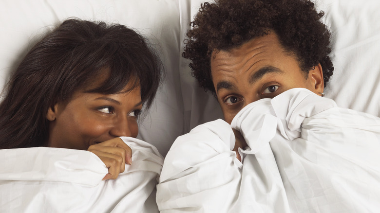 couple in bed under sheets