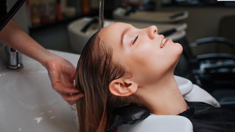 Woman having hair washed at salon