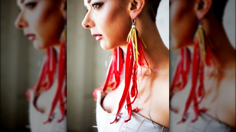 Woman wearing long red ribbon earrings