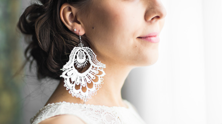 Woman wearing white lace earrings