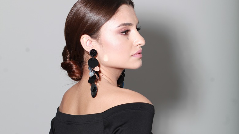 Woman wearing black earrings and black dress