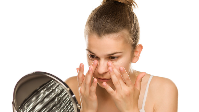 Woman applying concealer