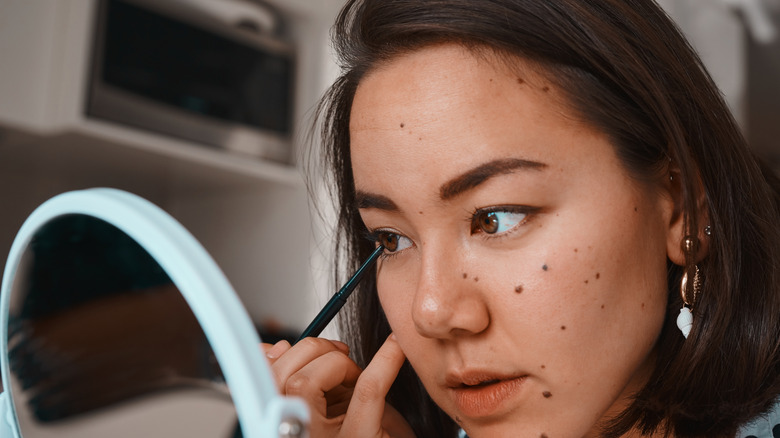 Woman applying eyeliner