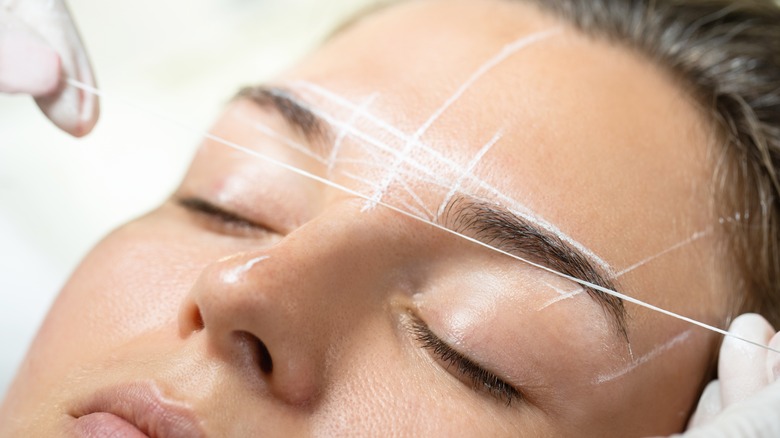 woman getting eyebrows mapped professionally