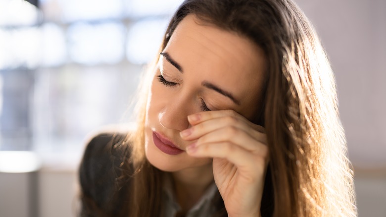 woman rubbing eye