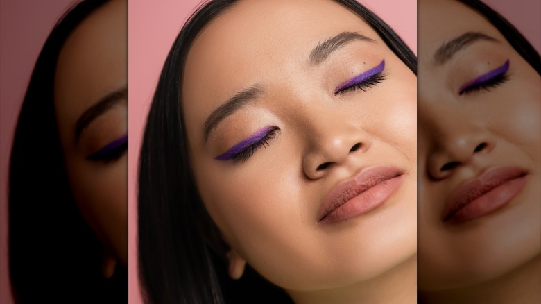 A woman wearing purple eyeliner.