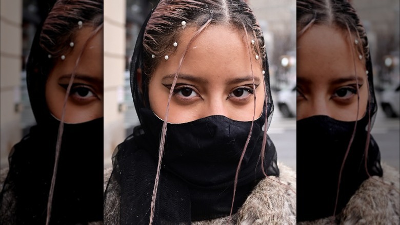 Woman in mask with twisted hair tendrils 