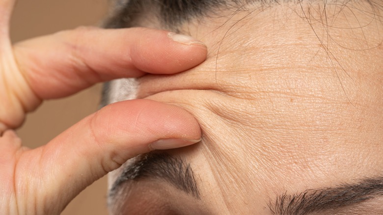 person pinching above eyebrow