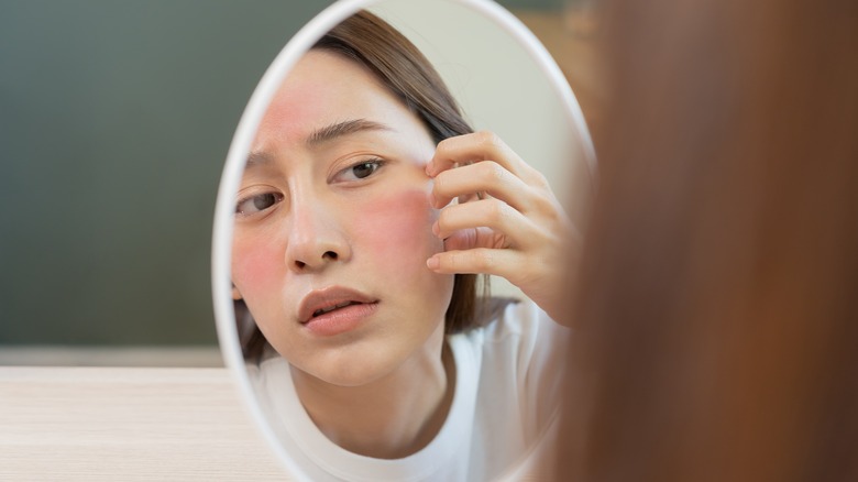 Woman with dry skin looking in mirror